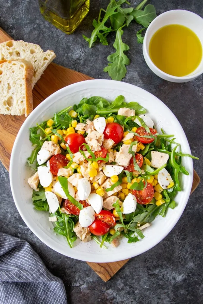 Bowl of Italian tuna salad with arugula, tomatoes and corn