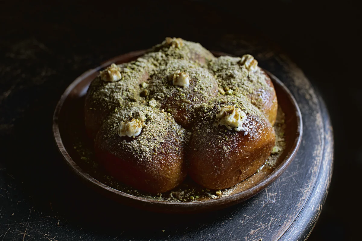 Kahlua buns dusted with salted pistachio powder in a bowl