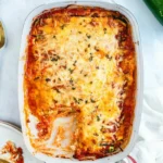 Baked zucchini lasagna with melted cheese and herbs in a white dish