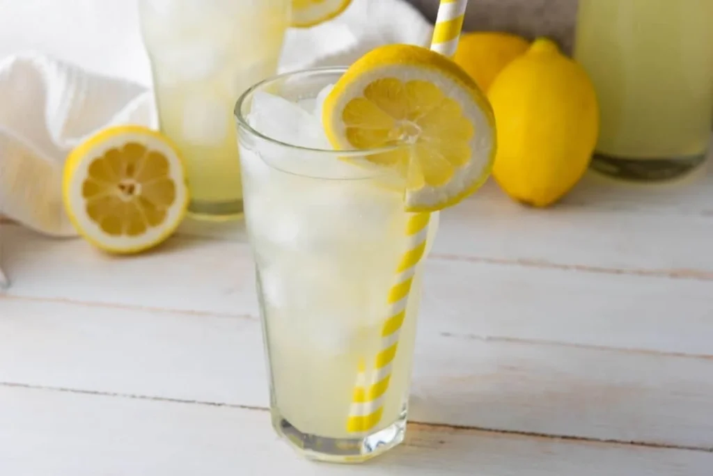 Tall glass of homemade lemonade with ice and lemon slice