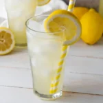 Tall glass of homemade lemonade with ice and lemon slice