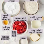 Vegan strawberry shortcake ingredients flat-lay on white marble