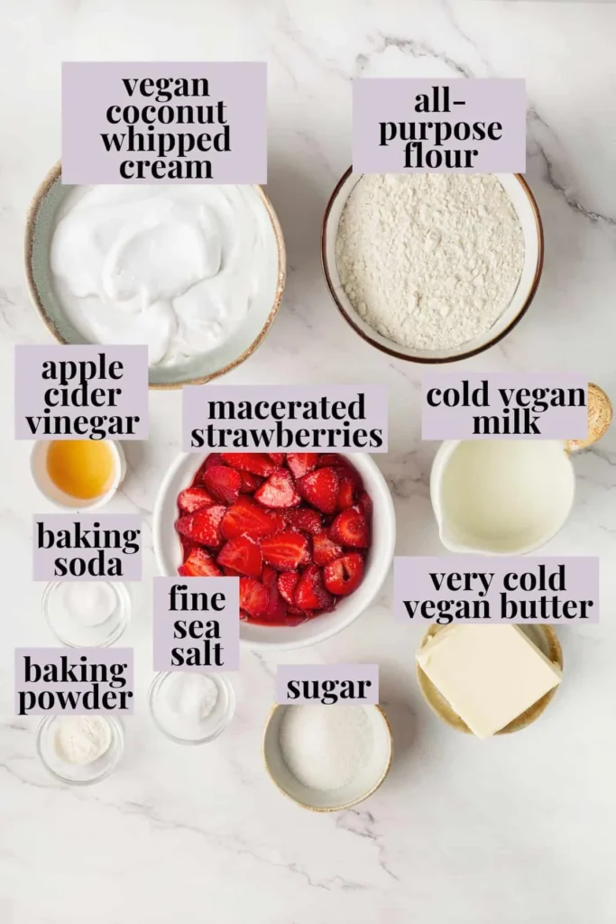 Vegan strawberry shortcake ingredients flat-lay on white marble