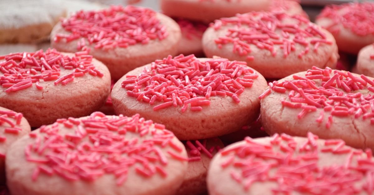 Pink-frosted cookies topped with pink sprinkle jimmies, close-up