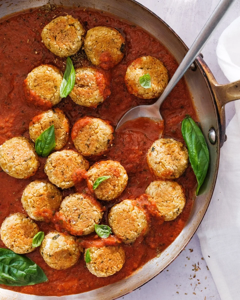 Vegetarian meatballs simmering in marinara, professional food photography