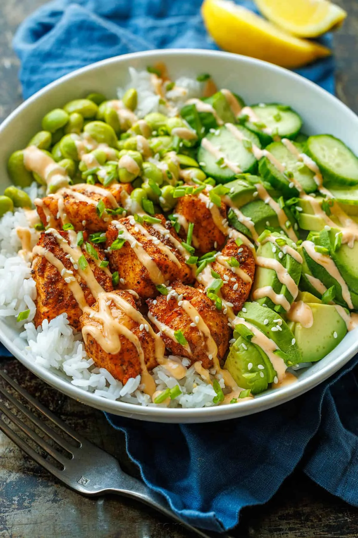 Close-up of assembled salmon bowl with bright green toppings