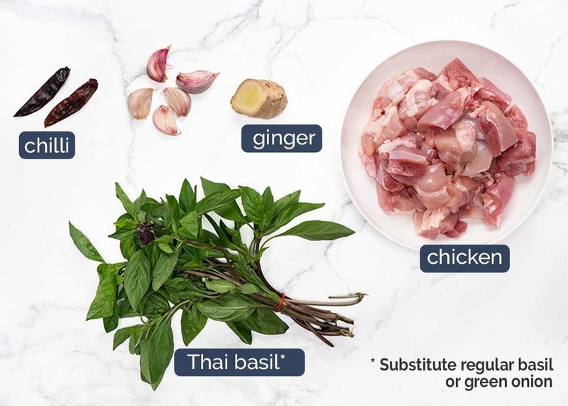 Flat-lay of chicken thighs, garlic, ginger, chillies and Thai basil