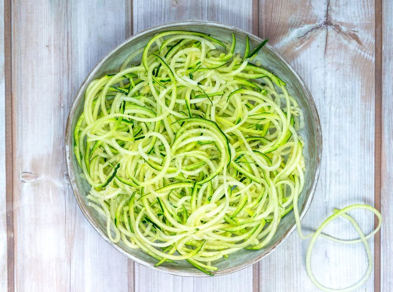 Shredded zucchini patted dry in a bowl before baking