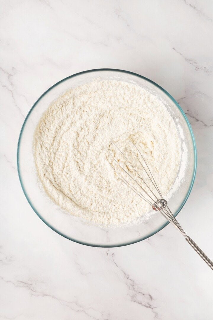 Flour and whisk in a glass mixing bowl