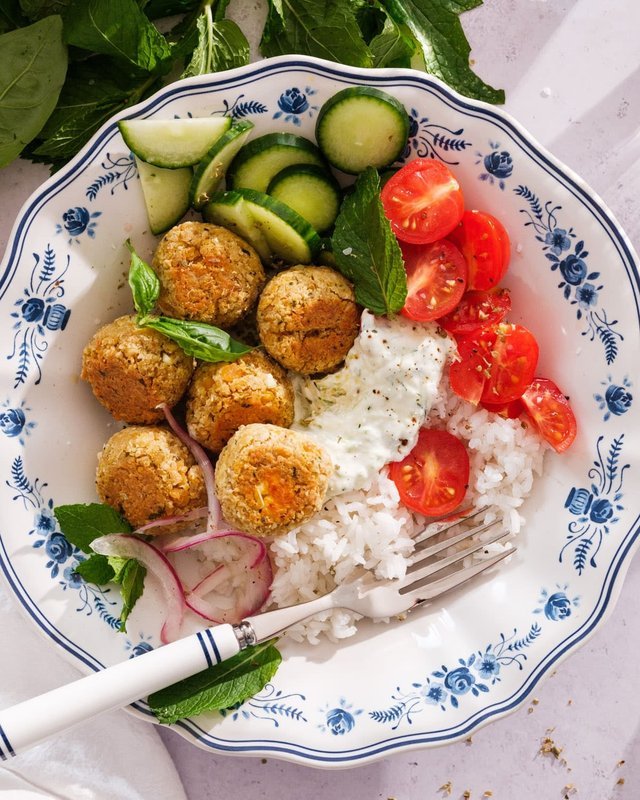 Mediterranean plate with rice, tomato, cucumber, and herb garnish