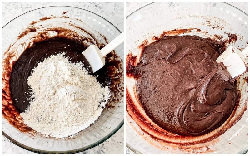 Flour being folded into smooth chocolate brownie batter