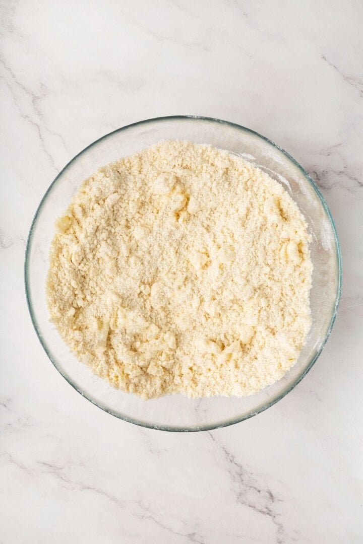Coarse crumbly biscuit dough in a glass bowl